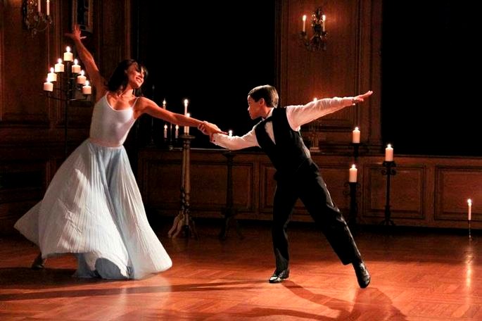 Película a través de Grace Alley. Un niño bien vestido y una mujer con un vestido suelto bailan en un elegante salón de baile