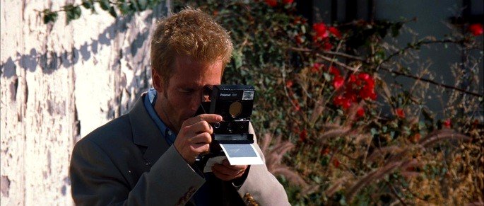 Fotograma: Leonard tomando fotografías.