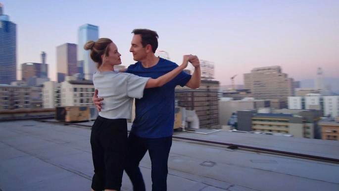 Una pareja bailando en lo alto de un edificio.